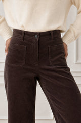 Model wearing the Aspiga Stretch Corduroy Trouser in Chocolate, a wide-leg corduroy trouser with patch pockets, alternate view