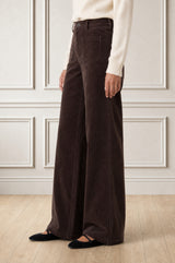 Additional styled photo of a model wearing the Aspiga Stretch Corduroy Trouser in Chocolate, a wide-leg corduroy trouser with patch pockets