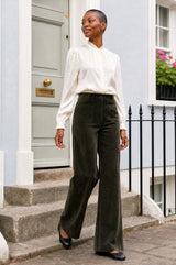 Additional styled photo of a model wearing the Aspiga Stretch Corduroy Trouser in Khaki, a wide-leg corduroy trouser with patch pockets