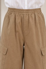 Close-up of the waistband and cargo pocket detail of the Aspiga Matcha Trousers in Camel