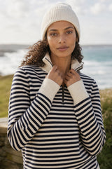 Additional styled photo of a model wearing the Aspiga Merino Wool Stripe Quarter Zip Jumper in Off White/Navy, a breton-striped quarter-zip jumper
