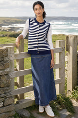 Lifestyle photo of a model wearing the Aspiga Merino Wool Stripe Button Knit Gilet in Navy/Off White, a breton-striped button-front knit gilet